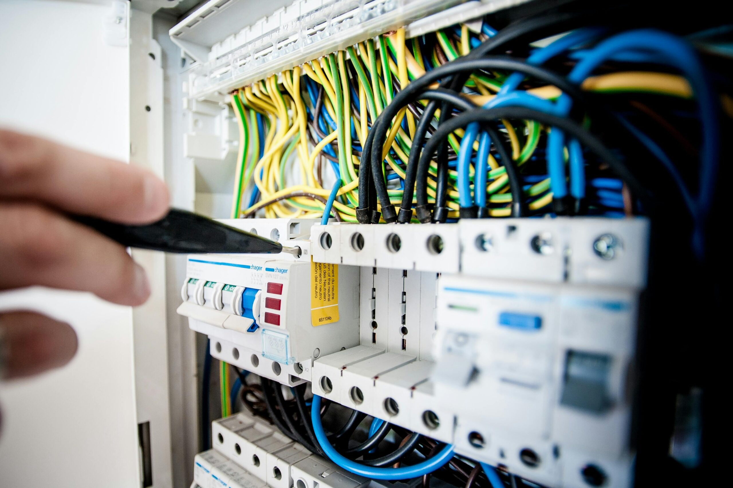 Electrician Fixing an Opened Switchboard Electrician Fixing an Opened Switchboard
